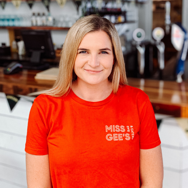 Ash Gee from Miss Gee's standing in her bar