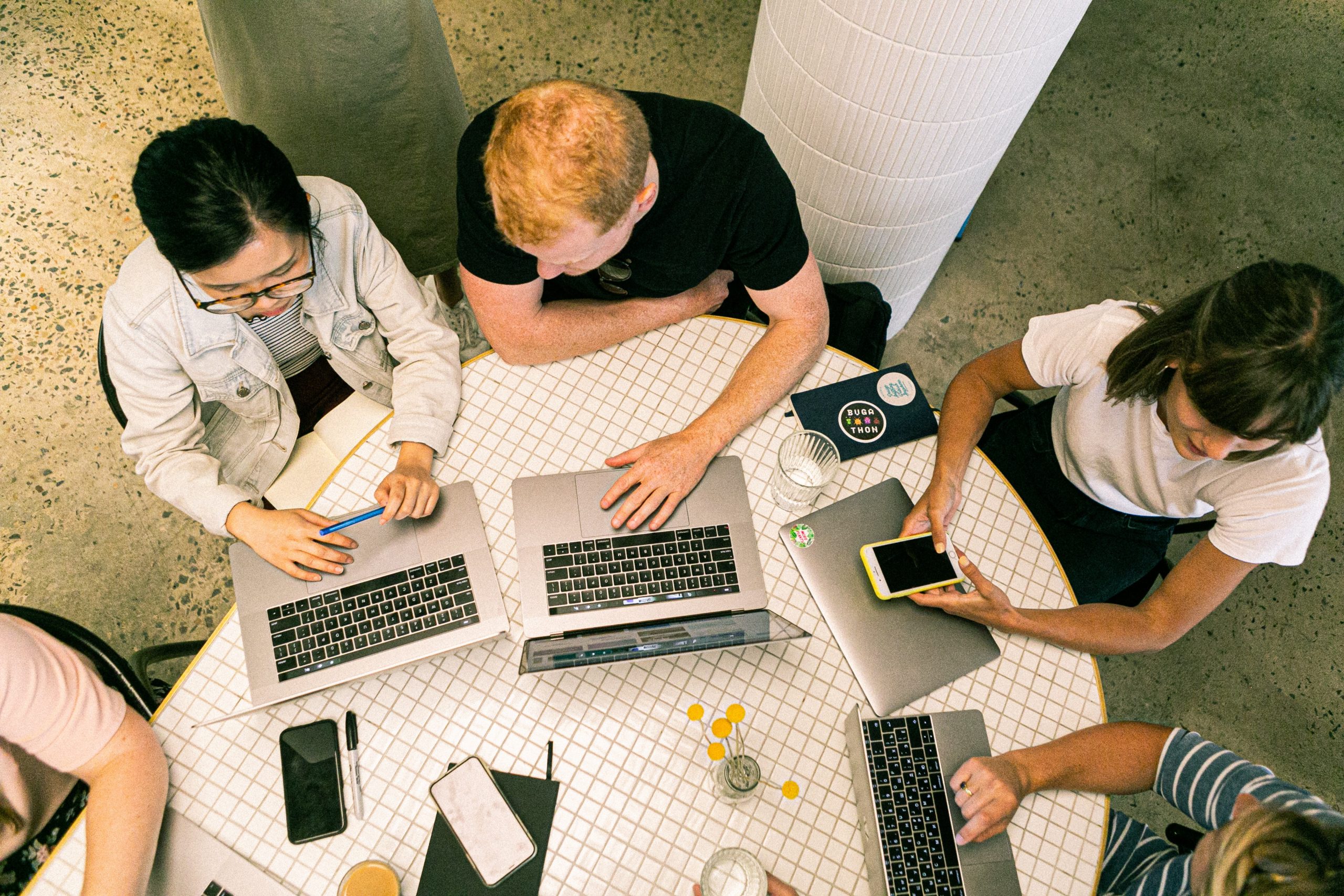 Photo of people working around laptops