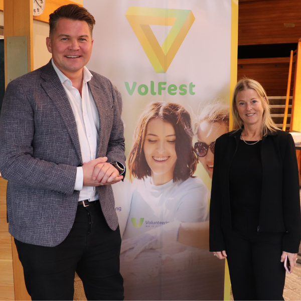 Matt Cowley and Lynette standing in front of a pull up banner forVolFest