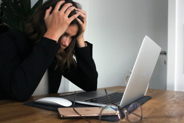 Woman holds her head in her hands feeling stressed