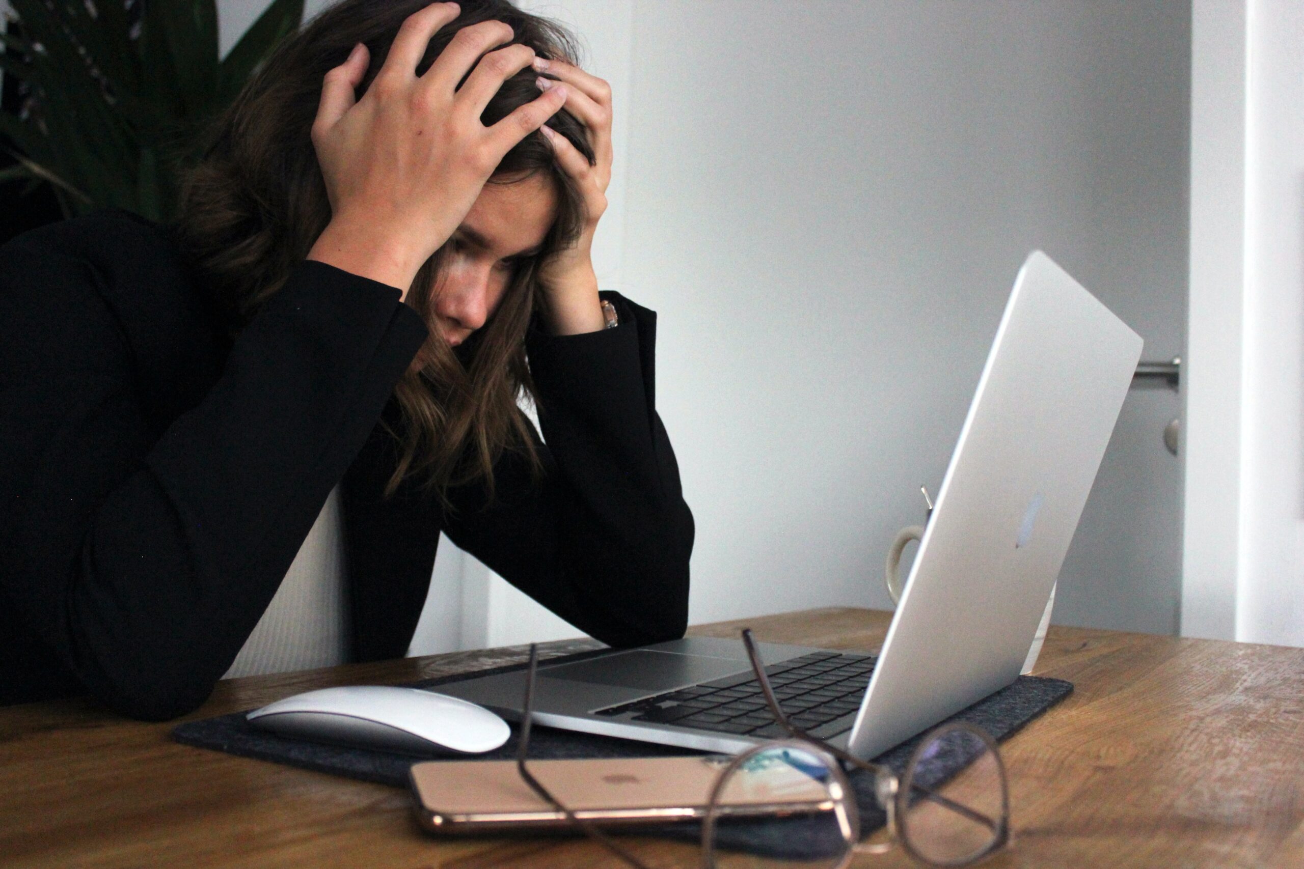 Woman holds her head in her hands feeling stressed